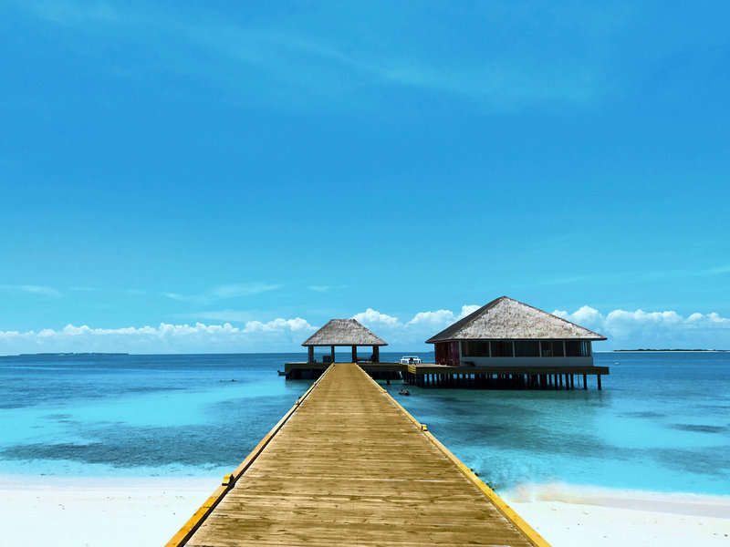Kudafushi Resort Malediven - Strahlend blauer Himmel über türkisfarbenem Meer