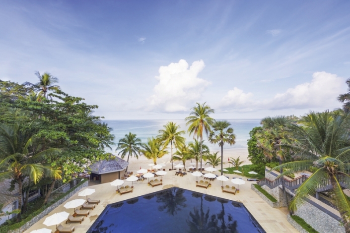 The Surin Phuket - Blick über den Pool und den Strand bis zum Meer